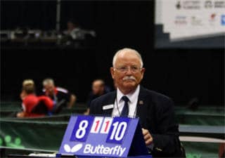 Schiedsrichter leitet Tischtennismatch, Punktestand 8:10, formelle Turnieratmosphäre mit Butterfly-Logo.