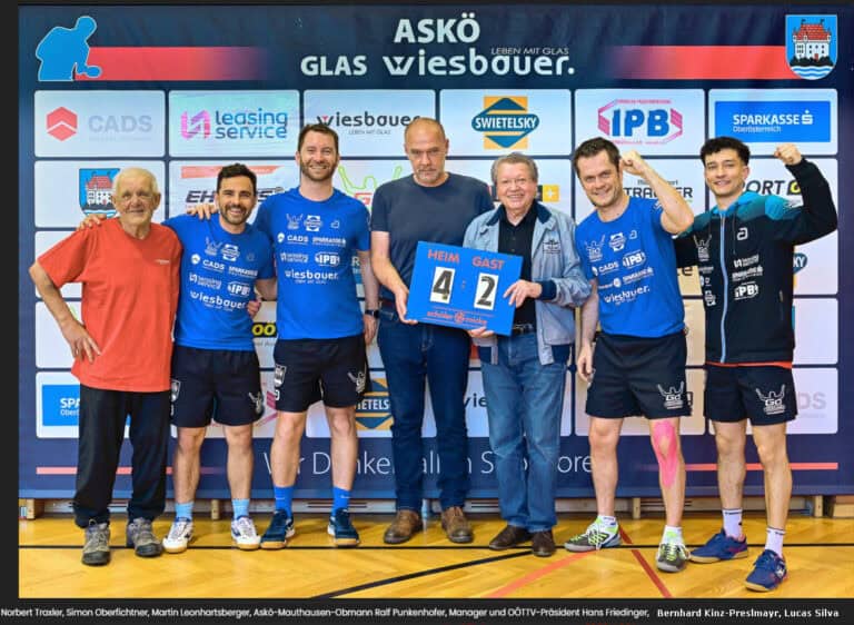 Sportlicher Sieg: Lachende Männer feiern 4:2 vor Sponsorwand, Teamgeist und Freude spürbar.