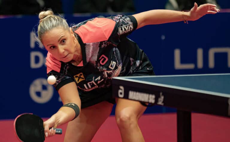 Damen-Tischtennis: Konzentration und Agilität bei professionellem Turnier mit farbenfrohem Outfit.