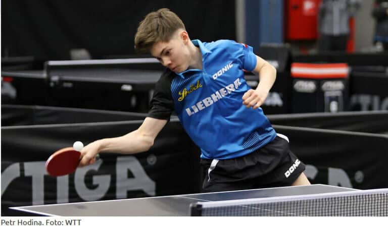 Petr Hodina konzentriert beim Tischtennis-Turnier, in blau-schwarzer Ausrüstung, mit rotem Schläger.