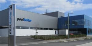 Modernes Gewerbegebäude von Pooldoktor in Österreich mit Glasfassade und gepflegter Außenanlage.