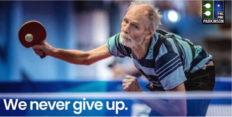 Ein älterer Mann spielt Tischtennis, zeigt Entschlossenheit und unterstützt Ping Pong Parkinson.